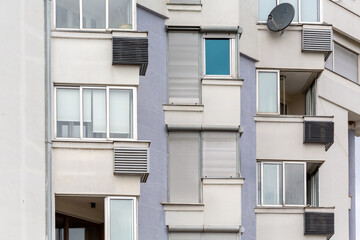  Modern apartment building facade with windows, balconies, and satellite dish showcasing urban architectural design