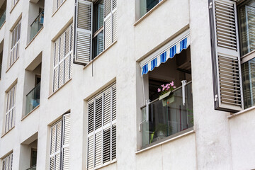  Modern apartment facade with open shutters and window awning against white walls for urban residential design