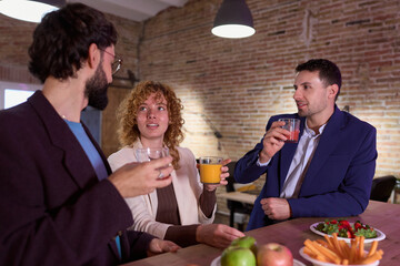 Businesspeople enjoying drinks and snacks during office break