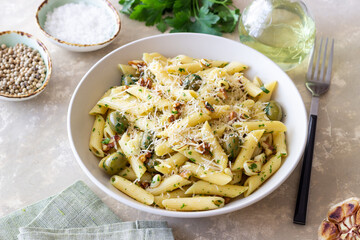 Pasta penne with olives, nuts, herbs and cheese. Healthy food. Italian cuisine. Vegetarian food.