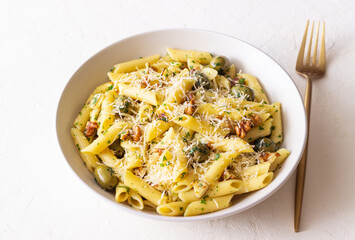 Pasta penne with olives, nuts, herbs and cheese. Healthy food. Italian cuisine. Vegetarian food.