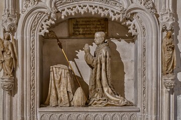Intricate stone sculpture of a kneeling religious figure.