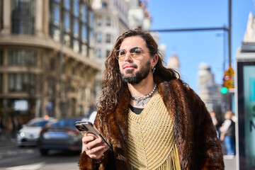 Stylish transgender person using smartphone in city street