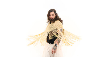 Latin transgender model posing with fringe shawl on white background