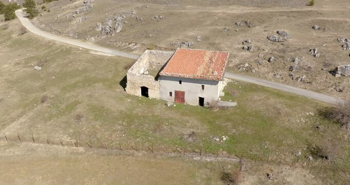 Aerial view of an abandoned mountain house. A rural road passes next to the road.