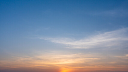 Obraz premium Soft pastel sunrise sky with delicate clouds, creating a calm natural background.