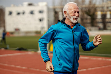 Senior runner running on stadium.