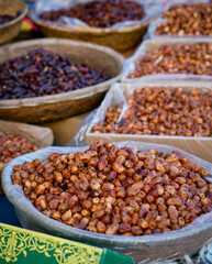 Baskets filled with different types of fresh and dried dates at a market.