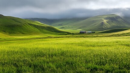 Fototapeta premium Green rolling hills and grassy meadow under a cloudy sky