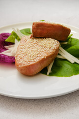 Freshly prepared tuna fillet with sesame seeds and vegetables on a plate