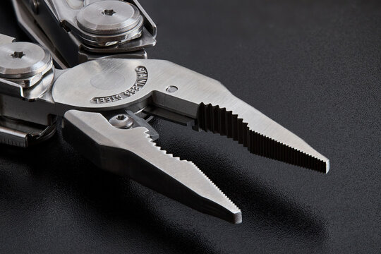 Pliers multi tool parts close up parts pivot point or fulcrum, pipe grip, tip, jaws or nose and handles. Pliers can grip, band, cut, and manipulate various materials. Focus stacking shot over black.