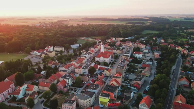 Aerial view of small town in suburban landscape at sunrise. Main square of European city with old town and church. Cityscape with colorful houses. Katy Wroclawskie, Poland