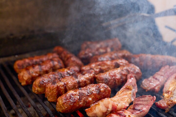 (Mici), traditional Romanian meat dishes on a grill during the cooking process