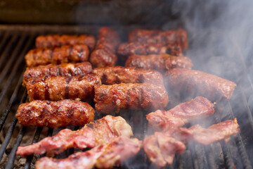 (Mici), traditional Romanian meat dishes on a grill during the cooking process
