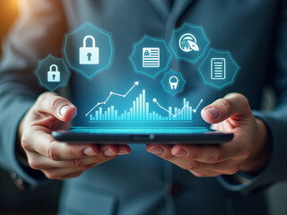 Close-up of business professional's hands holding tablet, displaying digital charts and security icons. Depiction of technological advancements in data security