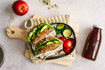 Sandwich mit Gurke und Blattsalat in einer Blech Brotdose. Draufsicht, Pausenbrot, Mittagessen zum Mitnehmen.