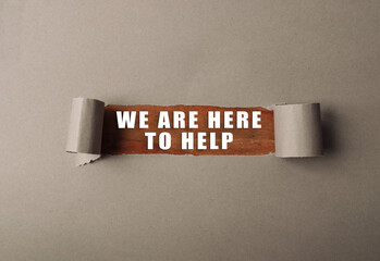 Torn piece of paper with the words We are here to help written on it. The image has a sense of...