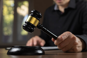 judge's gavel in hand judges is placed on a table in the legal counsel's office