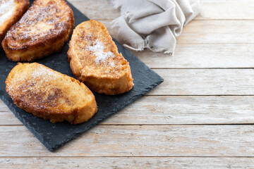 Traditional Spanish torrijas for Holy Week on wooden table. French Toast. Copy space