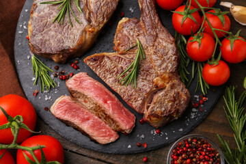 Pieces of delicious beef meat, spices and tomatoes on table, flat lay