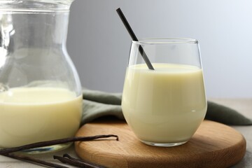 Delicious vanilla milk and pods on grey table