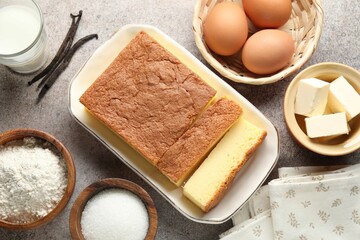 Tasty Japanese Castella sponge cake and ingredients on light table, flat lay