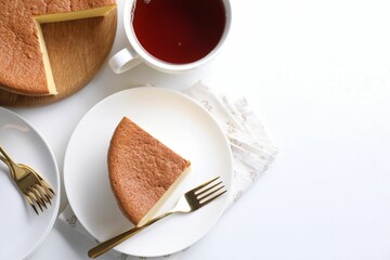 Tasty Japanese Castella sponge cake served with tea on white table, flat lay. Space for text