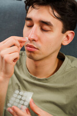 Using acne patches for facial skincare. Young guy sticking acne patches to forehead to clean skin...
