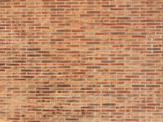 Brick wall with a red brick pattern. The wall is made of bricks and has a rough texture