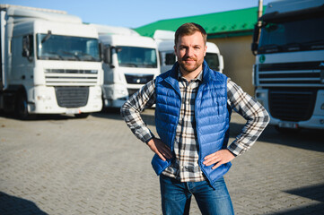 Happy confident male driver standing in front on his truck