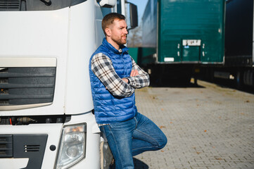 Happy confident male driver standing in front on his truck