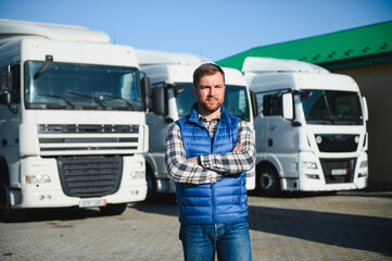 Happy confident male driver standing in front on his truck