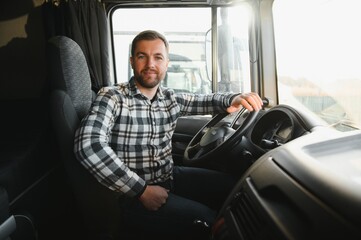 Obraz premium Close up of truck driver behind steering wheel. Copy space