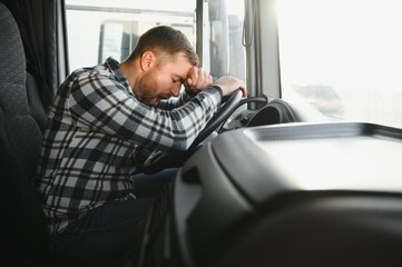 Exhausted truck driver falling asleep on steering wheel. Tiredness and sleeping concept