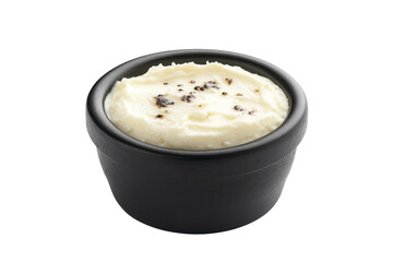 Creamy butter in a black dish with pepper flakes on top