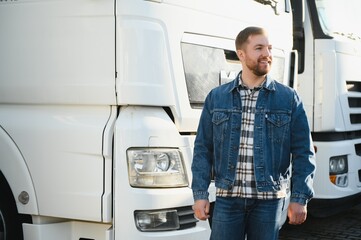 Happy confident male driver standing in front on his truck