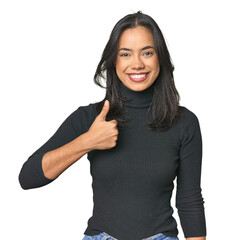 Simple portrait of a young Latina smiling and raising thumb up