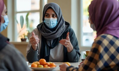 Three Women in Face Masks Share Conversation in a Bright Room
