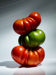Sweet farm tomatoes stacked over grey background