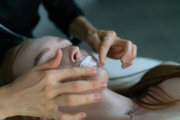 A skilled cosmetologist is carefully applying a lip botox treatment on a client