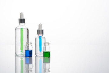 transparent dropper bottle with white bottom and colored dropper