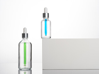 transparent dropper bottle with white bottom and colored dropper