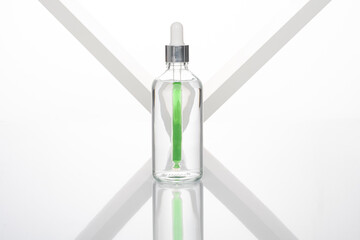 transparent dropper bottle with white bottom and colored dropper