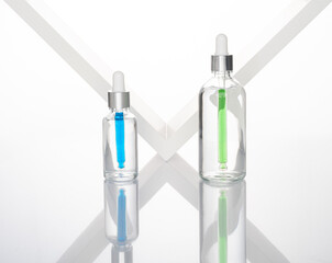 transparent dropper bottle with white bottom and colored dropper
