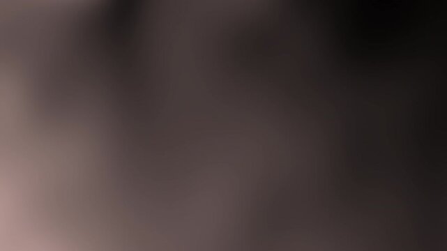 A soft-focus image featuring blurred tones, offering an abstract portrayal of color and light without distinct shapes or subjects.brown radient texture background