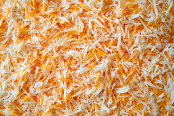 Close-Up of Freshly Grated White and Orange Cheese Texture Background


