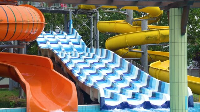 Colorful toboggan in a waterpark during the day, medium shot, handheld
