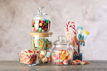 Candy bar. Many different sweets on wooden table against grey background