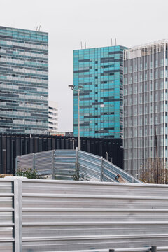 Modern urban architecture with high-rise glass buildings and geometric structures in a contemporary cityscape, showcasing minimalist design and clean lines.