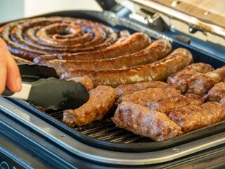 Grilled sausages and meats on a barbecue grill.